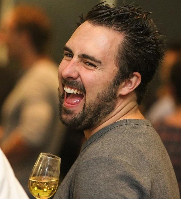 man laughing with whiskey in hand 